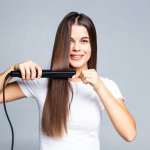 smiling-young-woman-straightening-her-hair-with-white-scaled.jpg